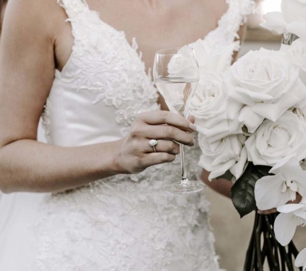 bride holding wine and wedding ring